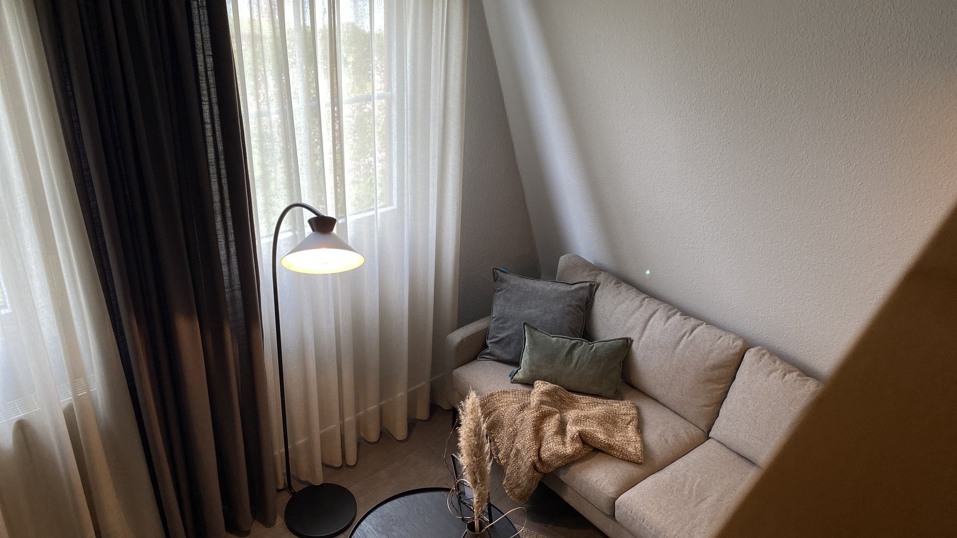 Unsere AGBs Gemütliches Wohnzimmer mit Sofa, Stehlampe und Kaffeetisch mit Dekoration