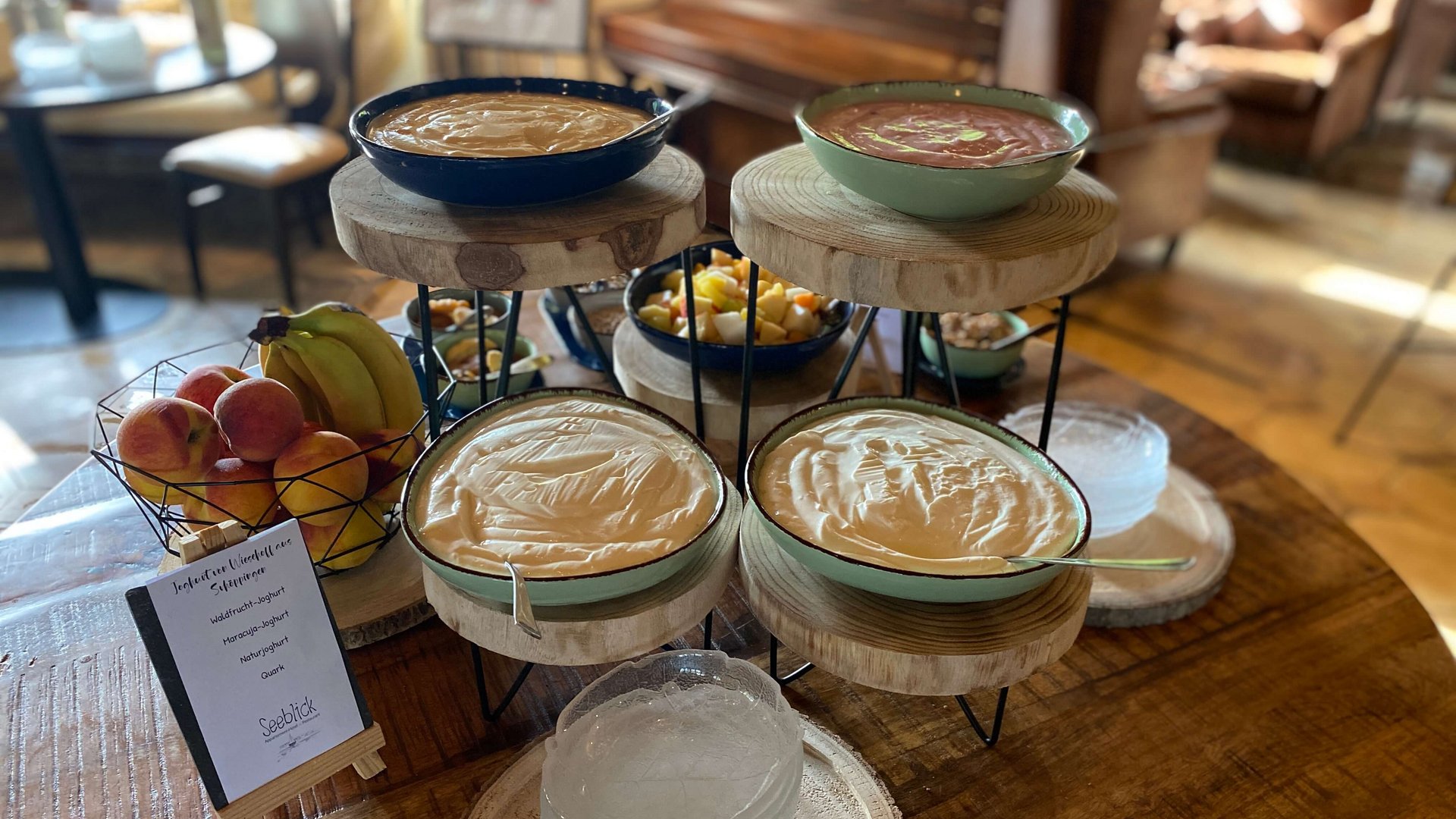 Frühstücken im Restaurant Seeblick in Gronau Joghurt und frisches Obst auf einem Holztablett in einem gemütlichen Raum
