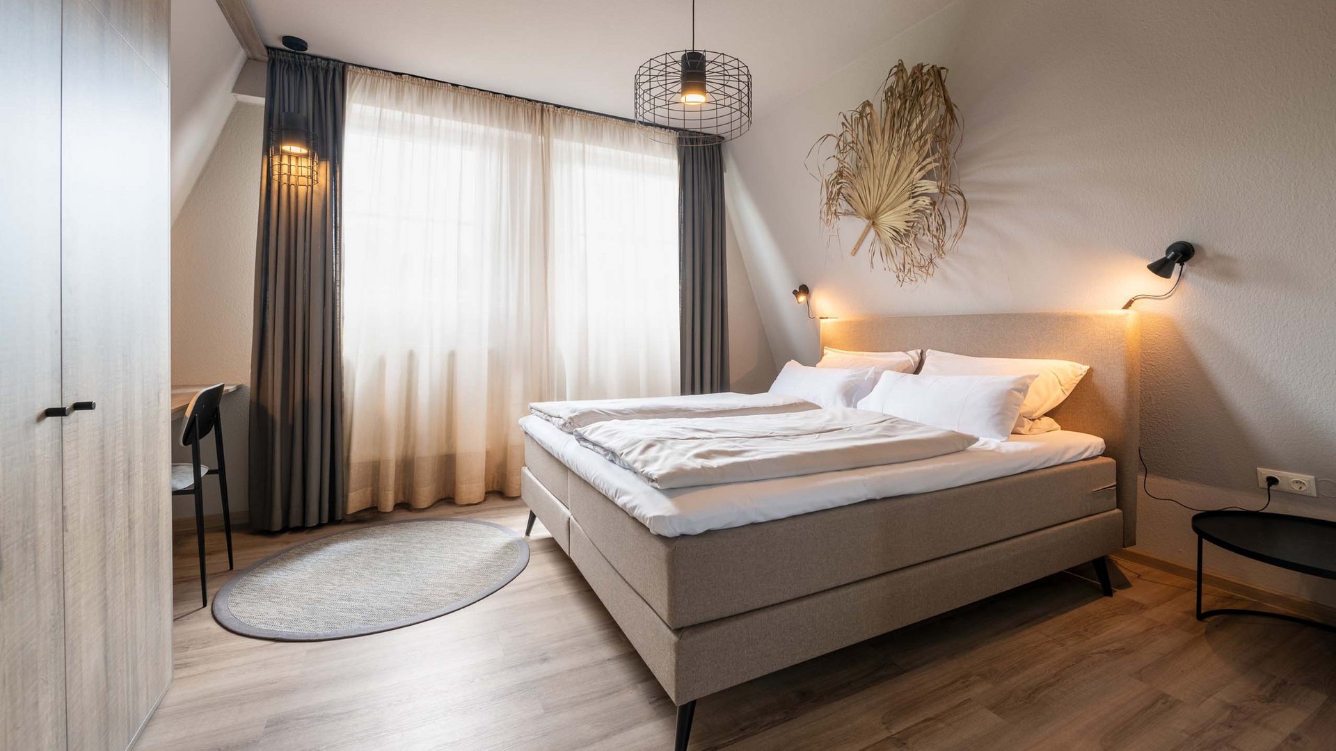 Unsere AGBs Gemütliches Schlafzimmer mit Doppelbett und natürlicher Dekoration an der Wand