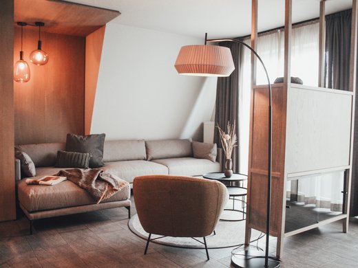 Seeblick Gronau: Urlaub inmitten der Natur Gemütliches Wohnzimmer mit Sofa, Sessel, Stehlampe und moderner Einrichtung