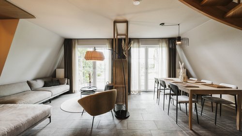 Restaurant Gronau: Seeblick Modern living room with sofa, armchair, large dining table, and large windows