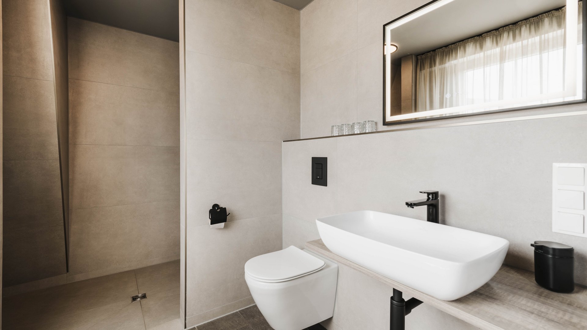 Seeblick Gronau: Urlaub inmitten der Natur Modernes Badezimmer mit hängendem WC, Waschtisch und beleuchtetem Spiegel