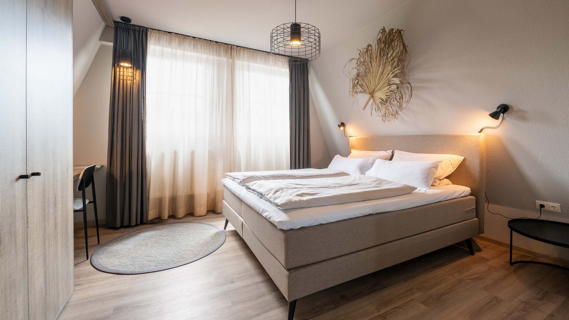 Seeblick Gronau: Urlaub inmitten der Natur Gemütliches Schlafzimmer mit Doppelbett und natürlicher Dekoration an der Wand