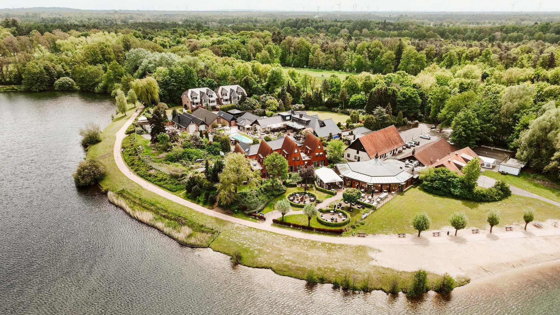 Seeblick Gronau: Urlaub inmitten der Natur Luftaufnahme eines Ferienresorts am See mit angrenzendem Wald